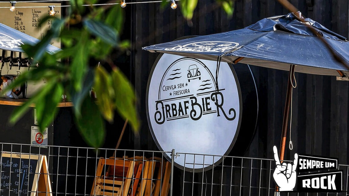Área externa do Orbafbier Garden na Serra da Cantareira com mesas de madeira, guarda-sol e ambiente ao ar livre entre natureza