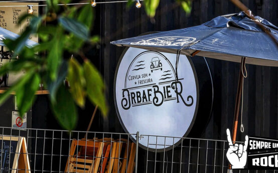 Área externa do Orbafbier Garden na Serra da Cantareira com mesas de madeira, guarda-sol e ambiente ao ar livre entre natureza
